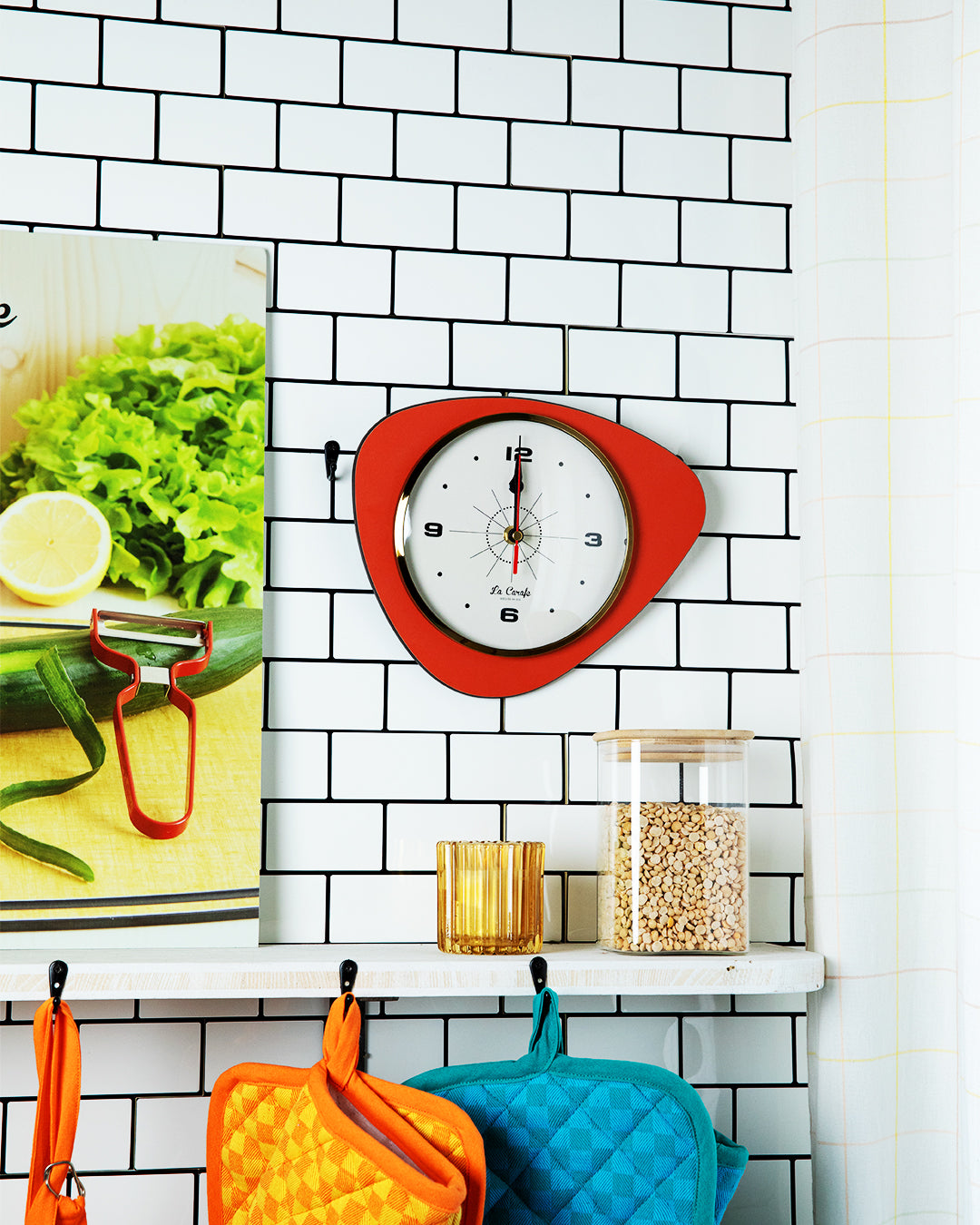 Horloge de cuisine originale rouge sur mur carrelé blanc, idéale pour cuisiner avec précision et style.