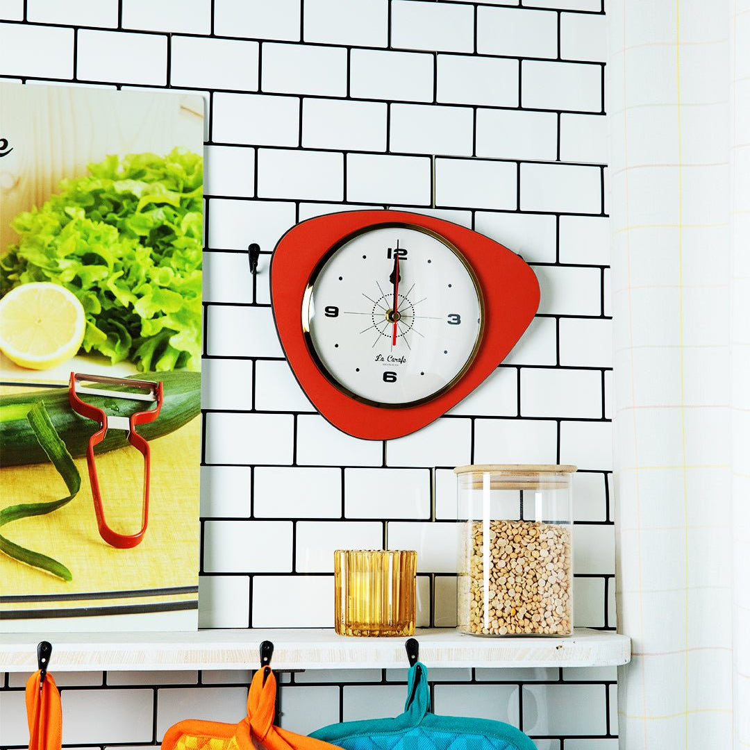 Horloge de cuisine originale rouge sur mur carrelé blanc, idéale pour cuisiner avec précision et style.