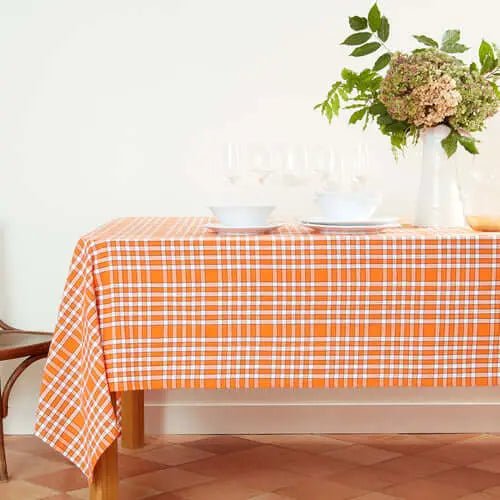 Nappe bistrot rectangulaire orange à carreaux épais 140x240cm en coton sur une table, ambiance conviviale et élégante.