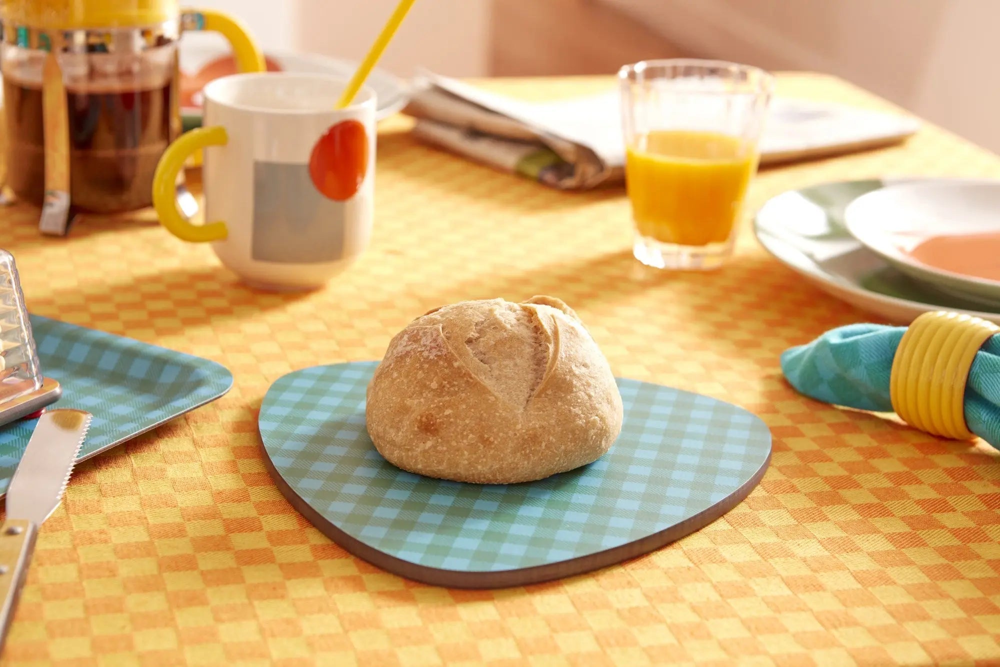 Dessous de plat médiator rétro en bleu, pain posé dessus, ambiance petit-déjeuner vintage, évoquant l'esprit des années 70.