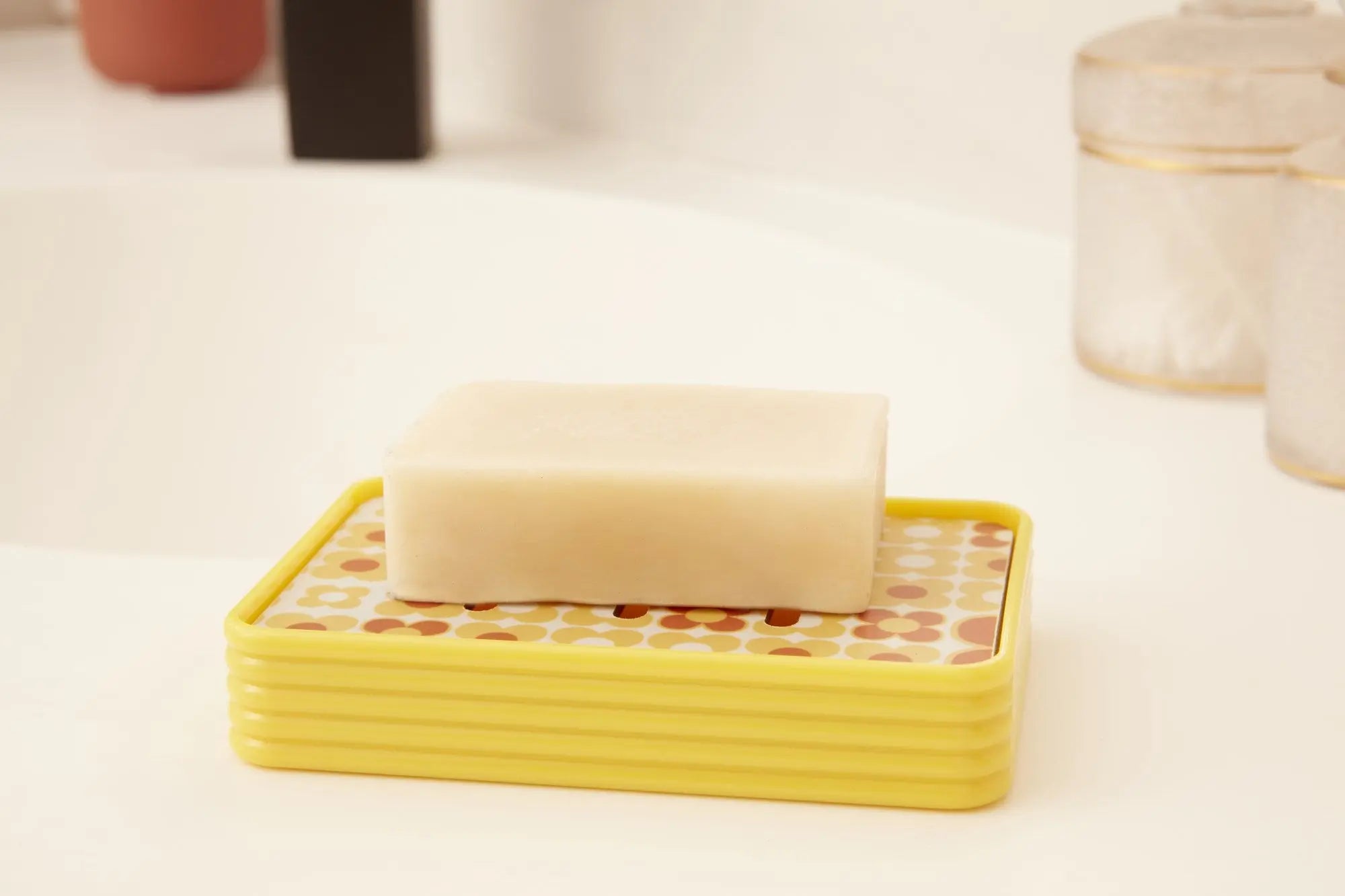 Porte-savon vintage jaune avec motif rétro, idéal pour une salle de bain au style années 60. Accessoire pratique et décoratif.