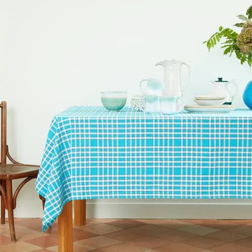 Nappe bistrot rectangulaire en coton, motif à carreaux, 140x240cm, avec vaisselle et accessoires sur une table en bois, ambiance conviviale.