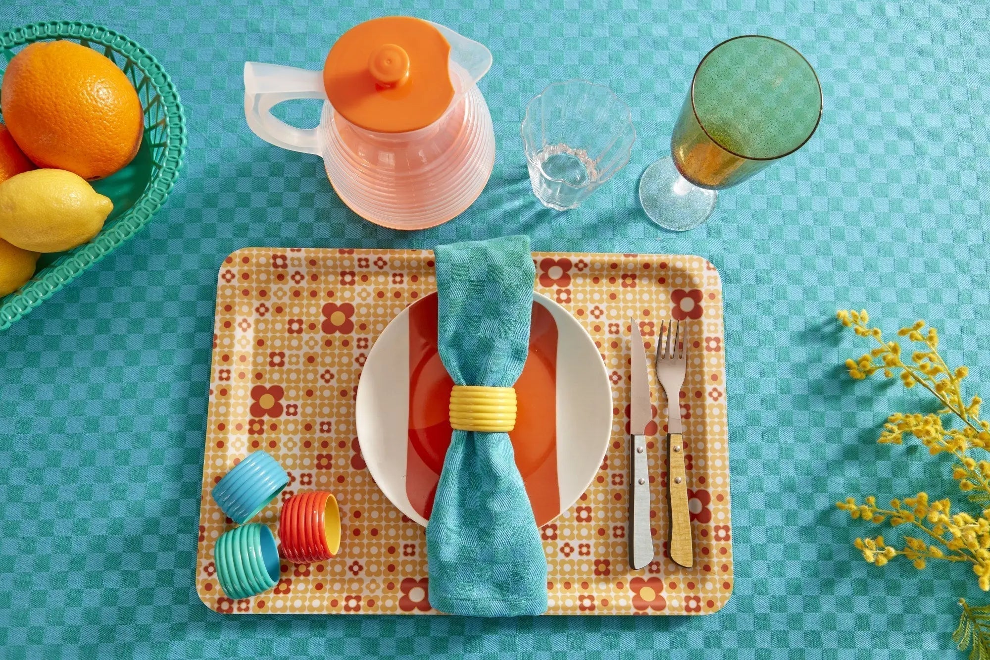 Table vintage turquoise avec serviette retenue par un rond de serviette jaune citron