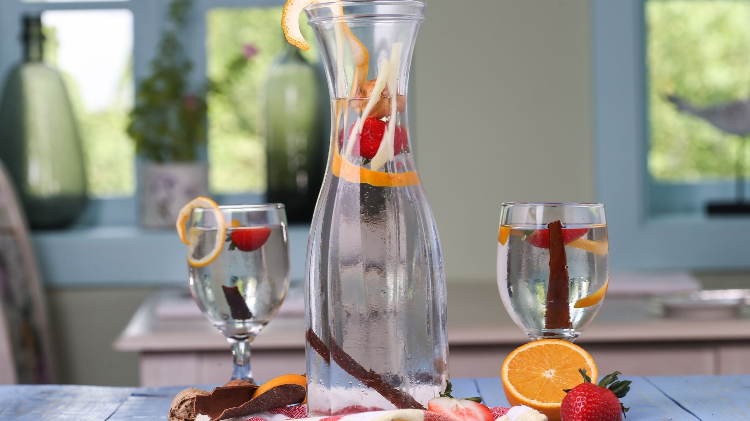 Carafe et verres d'eau aromatisée aux fraises et à l'orange sur une table d'été