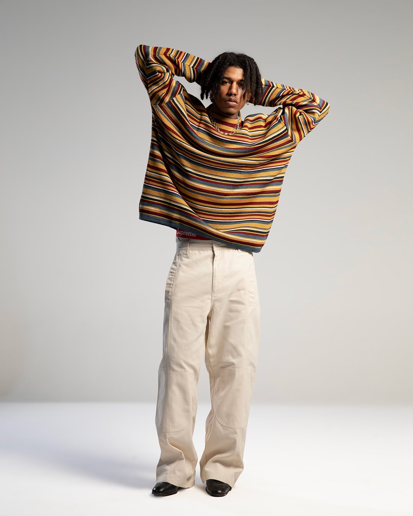 Collection vêtements DDP : pull rayé multicolore oversize porté, pièce culte de la marque bordelaise