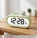 Réveil digital enfant vert amande avec figurine panda, vue sur bureau en bois