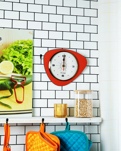Horloge de cuisine originale rouge sur mur carrelé blanc, idéale pour cuisiner avec précision et style.