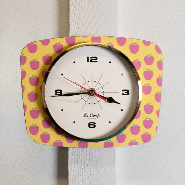 Horloge murale rectangulaire motif pommes – Cadran beige au design rétro années 50-70, objet de décoration maison vintage.