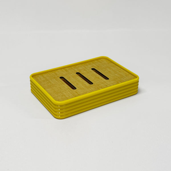 Le porte-savon vintage en plastique jaune et bois, style rétro des années 60 pour décoration maison vintage élégante.